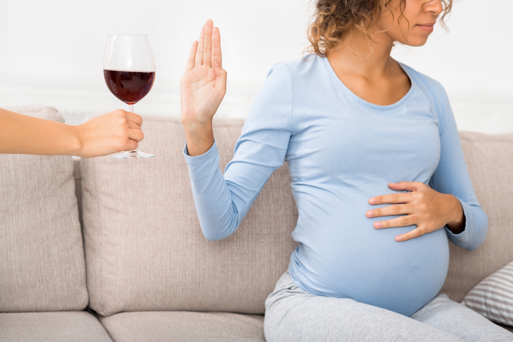 Une femme enceinte refusant un verre de vin